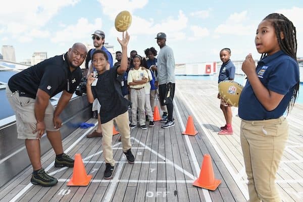 former New Orleans Saints running back Deuce McAllister (left) works with students from Kipp Central City Primary School. (Photo by Erika Goldring/Getty Images)