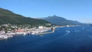 Nestled at the edge of a forested hill, this coastal town offers a vibrant marina where boats dance across the shimmering ocean. With hills and a clear blue sky as its backdrop, it feels like stepping into a scene from the Juneau Cruise Port Guide.