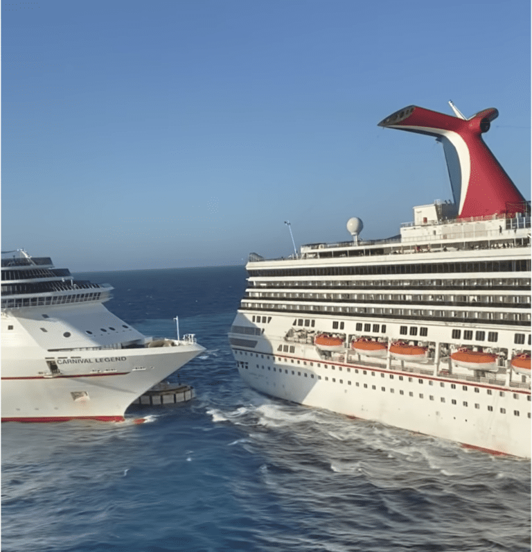 Two Carnival Cruise Ships are colliding in the ocean near Cozumel. The ship on the left has "Carnival Legend" written on its hull, while the ship on the right boasts a distinctive red and white funnel. Both vessels are surrounded by shimmering water under a clear blue sky.