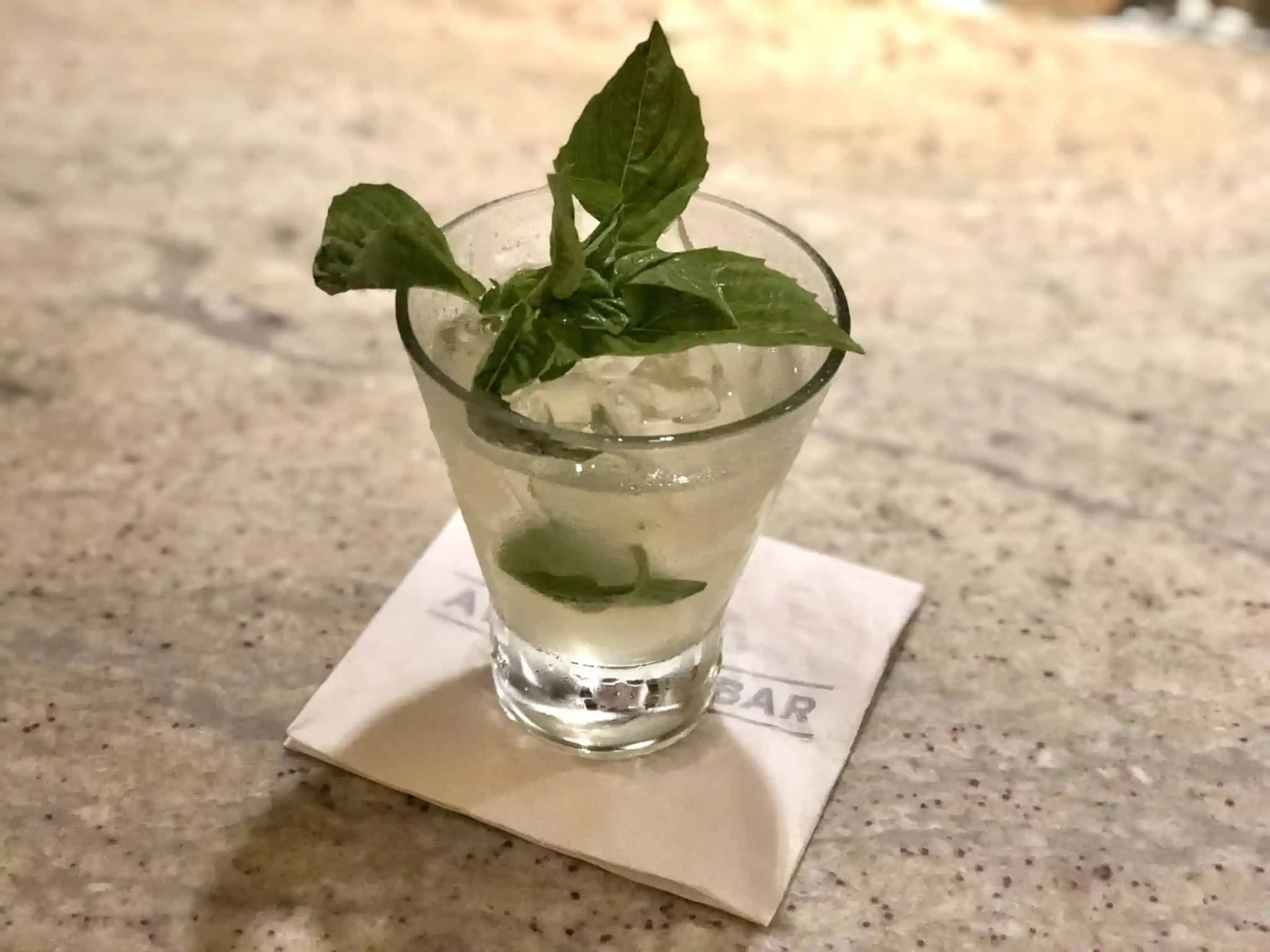 Image of the Restorative Basil Drop cocktail made at a Carnival Cruise Line Alchemy Bar.