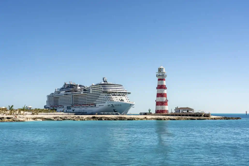 A year-round cruise ship from MSC Cruises floats gracefully in front of a lighthouse in Ocean Cay.