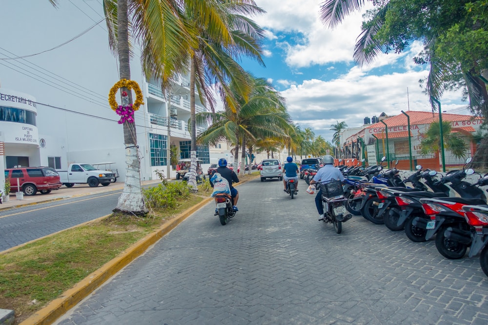 A couple on motorcycles in Mexico, with a passenger.