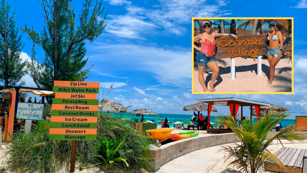 A woman is standing in front of a sign at a beach in the Bahamas.