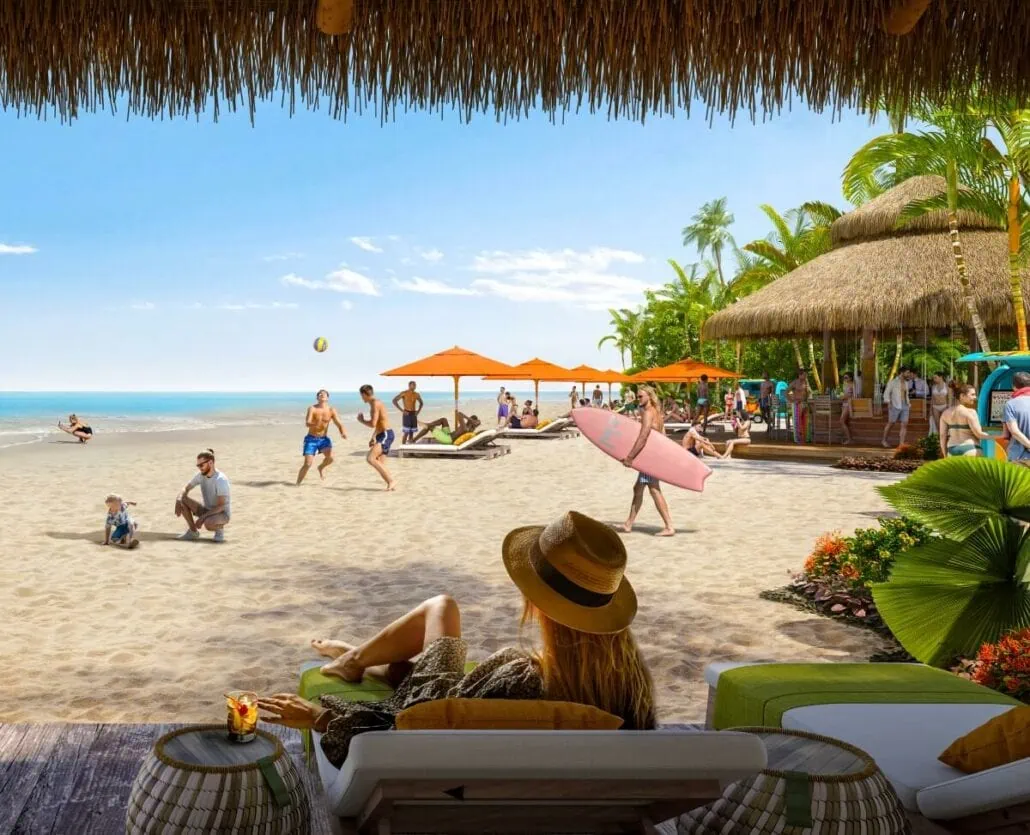 A bustling beach scene with people sunbathing, playing volleyball, and enjoying a seaside bar under a clear blue sky.