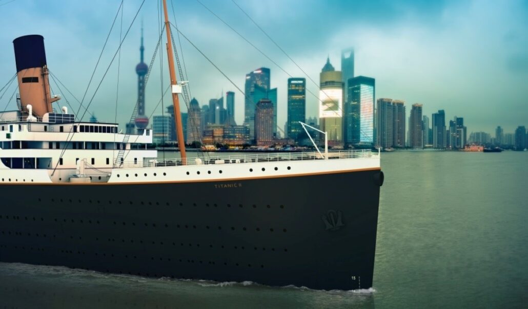 A modern Titanic in the water with a city in the background.