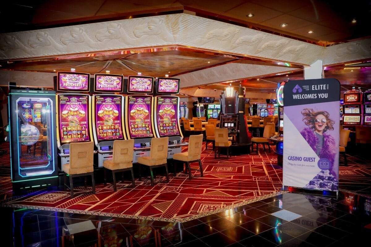 Interior of a casino with vibrant slot machines and a welcoming sign for "elite" guests.
