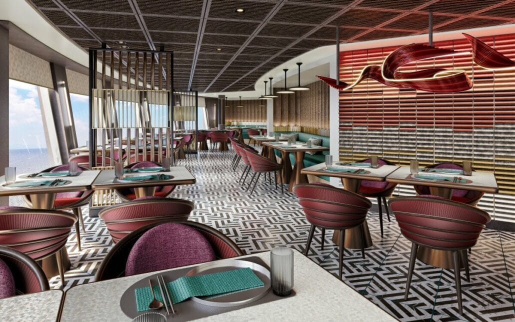 Modern restaurant interior with geometric patterned floor, red and teal chairs, large windows overlooking the sea, and unique red ceiling lights.