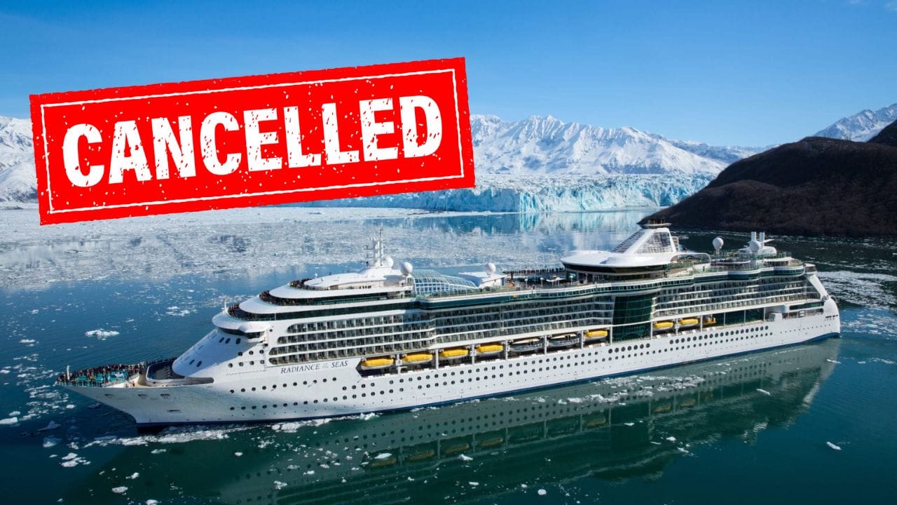 A large Royal Caribbean cruise ship is sailing through icy waters with snow-covered mountains in the background. A bold red stamp with the word "CANCELLED" is prominently displayed across the top left corner of the image, much to the dismay of awaiting guests.