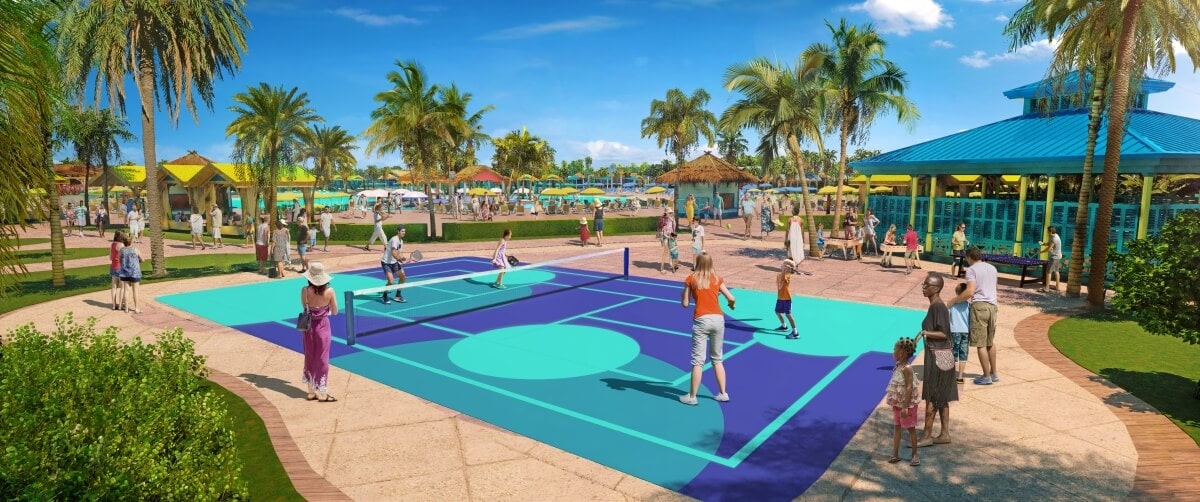 People playing pickleball on two courts surrounded by tropical palm trees at Starfish Lagoon, with other visitors enjoying a sunny day at the recreational facility in the background.