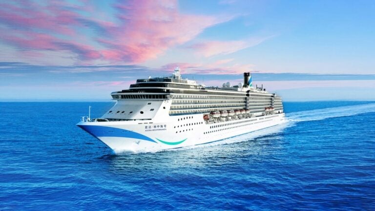 A large white cruise ship sails on the open ocean under a pink and blue sky, with crew members vigilantly ensuring safety following recent incidents.