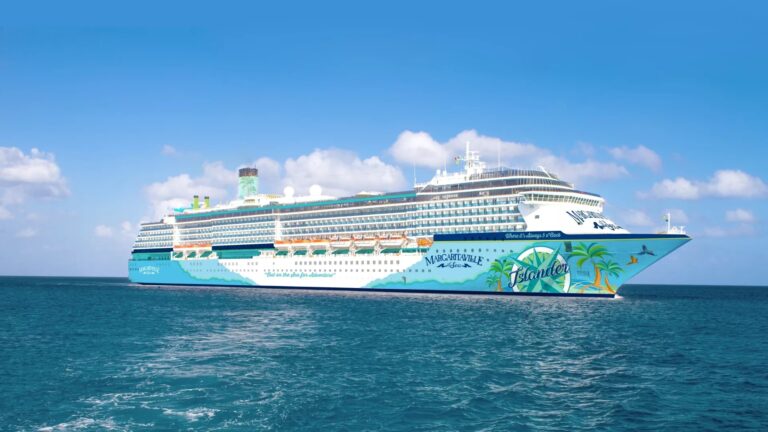 Large cruise ship named "Norwegian Getaway" sailing in clear blue waters under a partly cloudy sky, adorned with colorful artwork featuring palm trees and ocean scenes—perfect for fans of Margaritaville at Sea.