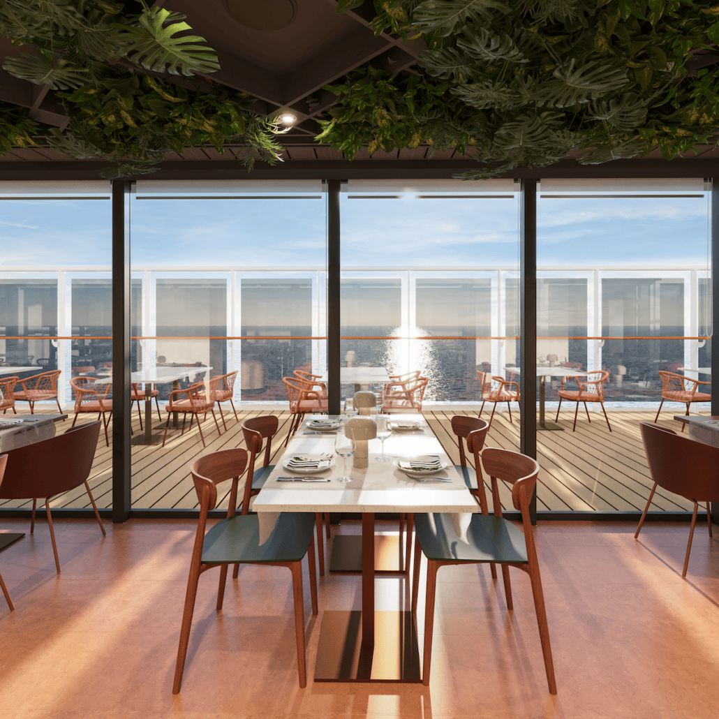Eataly at Sea offers a modern dining experience with a view of the ocean through large glass windows. The interior features wooden chairs and marble tables, while the outside deck has seating for outdoor dining under clear skies. Lush green plants hang from the ceiling, creating a serene atmosphere aboard MSC World America.