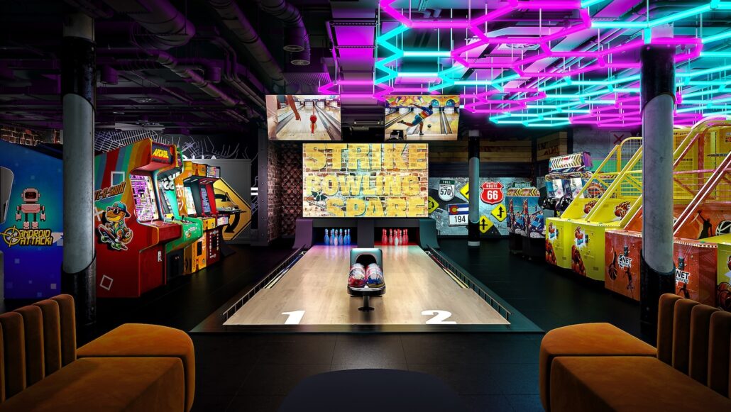 A vibrant indoor entertainment center featuring a single bowling lane with neon lights and arcade games on the sides, reminiscent of the lively atmosphere on Norwegian ships. The ceiling boasts colorful geometric lighting, while a large screen displays "Strike Power Score.