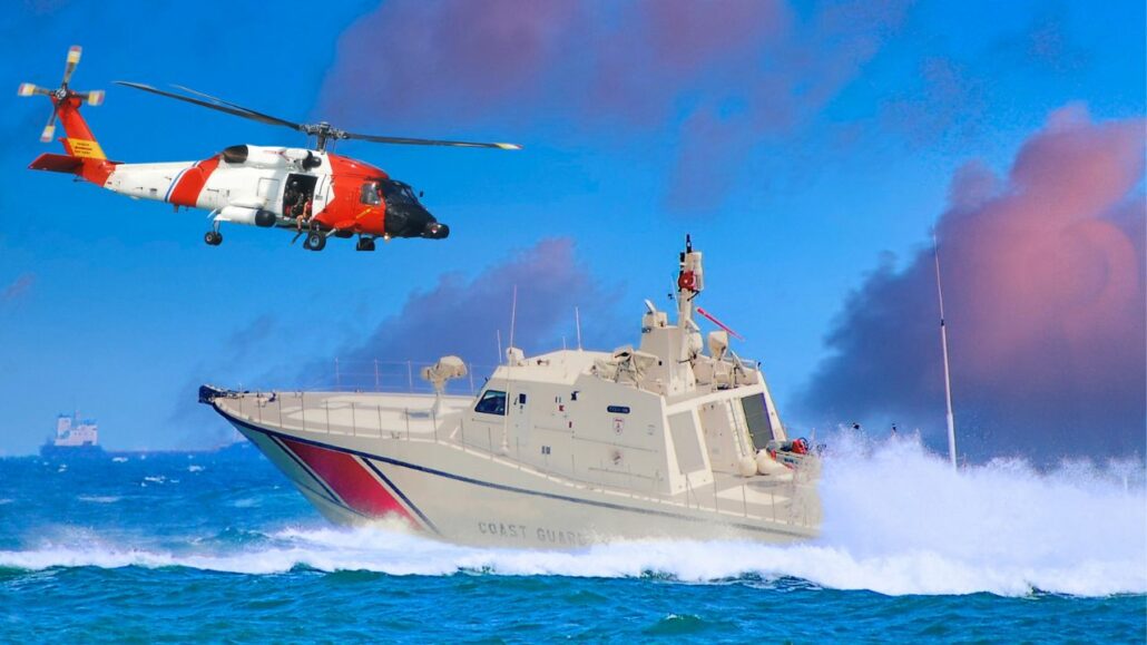 A coast guard helicopter and patrol boat are on a search mission in rough seas. The helicopter hovers above the water, tirelessly scanning for the 66-year-old reported overboard, while the boat speeds through waves. A cargo ship is visible in the distant background under a clear blue sky.