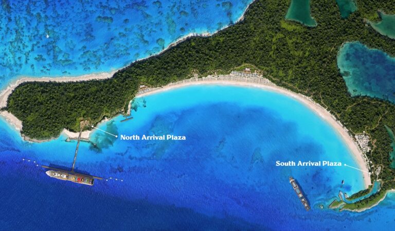 Aerial view of Half Moon Cay, a tropical paradise with lush greenery and a curving sandy beach bordering turquoise waters. Two labeled areas indicate the North Arrival Plaza and South Arrival Plaza, where Holland America ships are docked offshore.