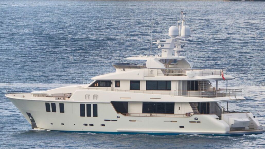 A large white luxury yacht, reminiscent of the elegance of Royal Caribbean's Allure of the Seas, floats gracefully on the water. The vessel boasts multiple decks and a sleek design, with railings and antennas adorning the upper level while the surface glistens in the background.