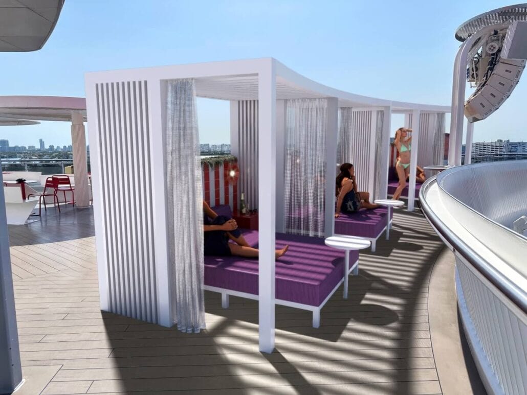 Outdoor cabanas with purple cushions and draped curtains are arranged on a deck aboard the Scarlet Lady. Guests relax inside the cabanas, enjoying top-notch service. A woman in a swimsuit walks nearby, set against modern architecture and a distant city skyline under a clear blue sky.