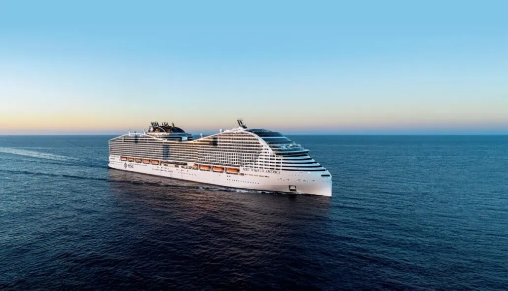 A large white cruise ship, reminiscent of an MSC Super Bowl Commercial, sails on the open sea under a clear blue sky. The ship features multiple decks and a streamlined design. As the sun sets, casting a warm glow over the scene, surprise celebrities wave from the horizon in the distance.