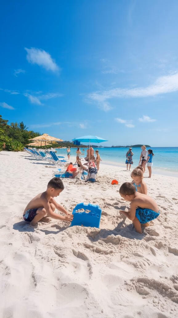 Children are enjoying kid-friendly activities with sand toys on a sunny beach. In the background, people relax on beach chairs under umbrellas near the water. The sky is clear, and the greenery around completes this perfect setting for a Caribbean cruise stop.