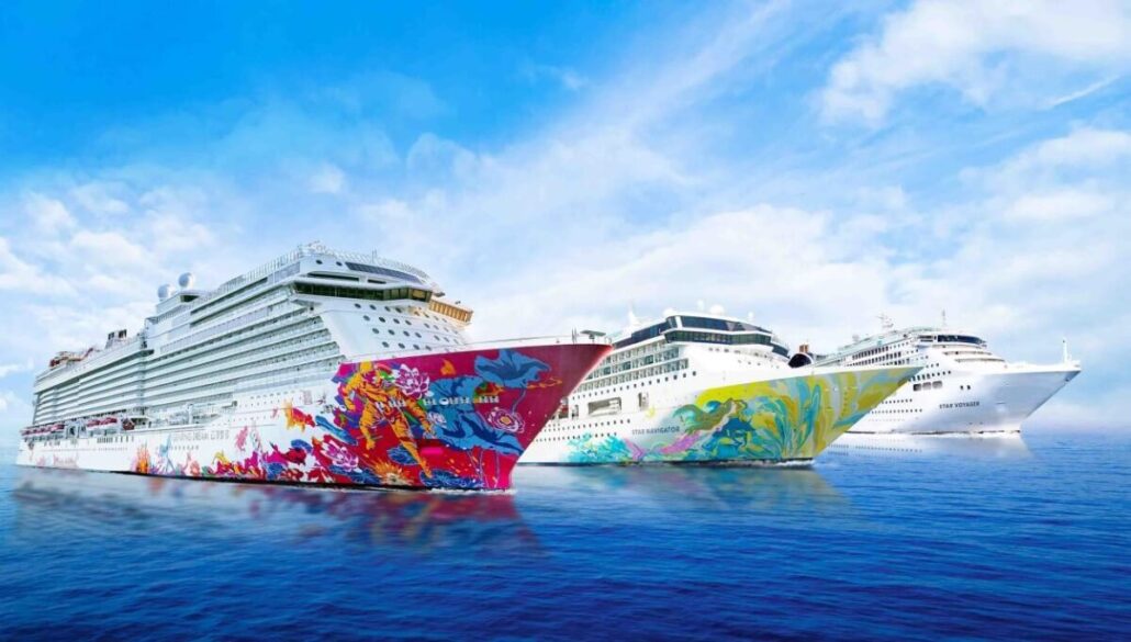 Three large, colorful cruise ships from Dream Cruises are sailing on a calm sea under a blue sky with scattered clouds. The ships feature vibrant artwork on their hulls and are moving in the same direction.