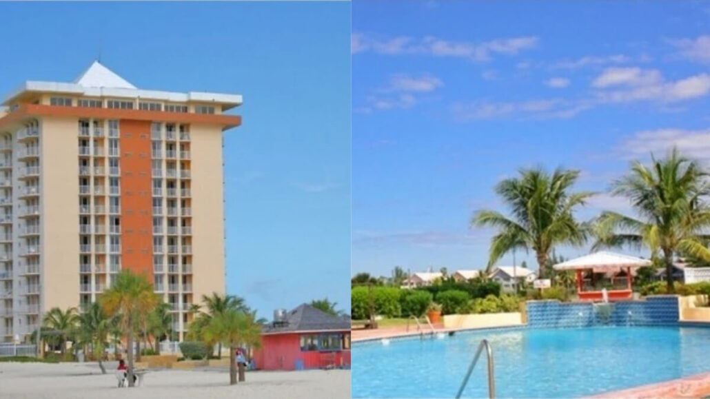 A tall, multi-story Bahamas resort with balconies stands near a sandy beach lined with palm trees. Next to it, a swimming pool with lounge chairs gleams under a clear blue sky at this stunning $300M Royal Caribbean destination.
