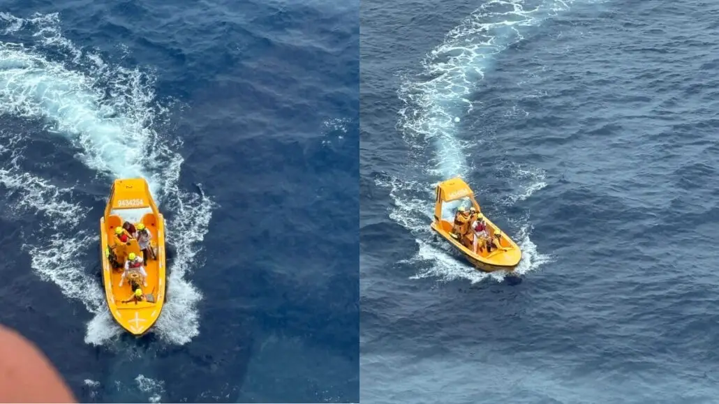 Two small yellow rescue boats with people wearing life jackets are moving through the blue ocean, leaving white wakes behind them. The boats are photographed from above.