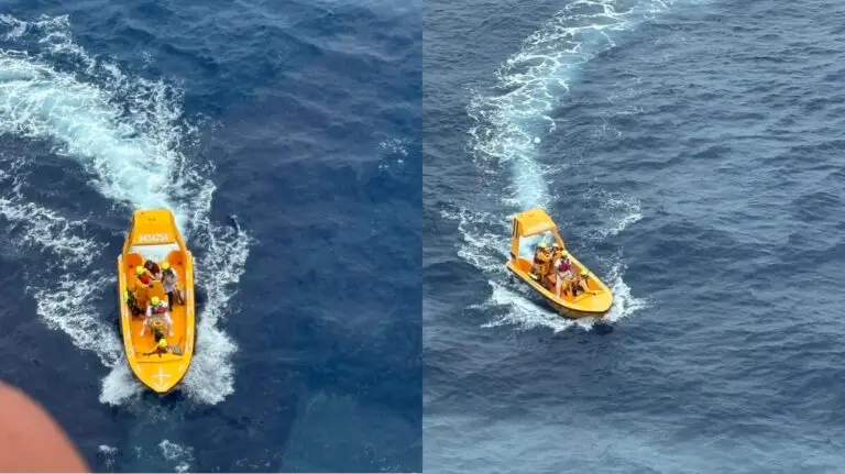 Two small yellow rescue boats with people wearing life jackets are moving through the blue ocean, leaving white wakes behind them. The boats are photographed from above.