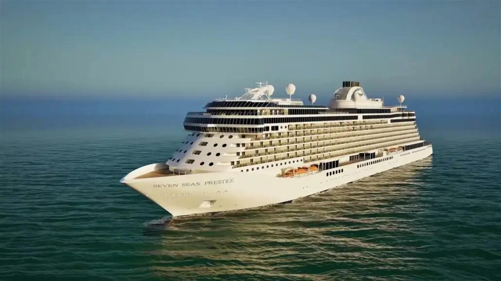 The new ship, Seven Seas Prestige by Regent, sails on calm ocean waters under a clear blue sky. Multiple decks, lifeboats, and the luxurious Skyview Suite are visible along the sides of this stunning cruise vessel.