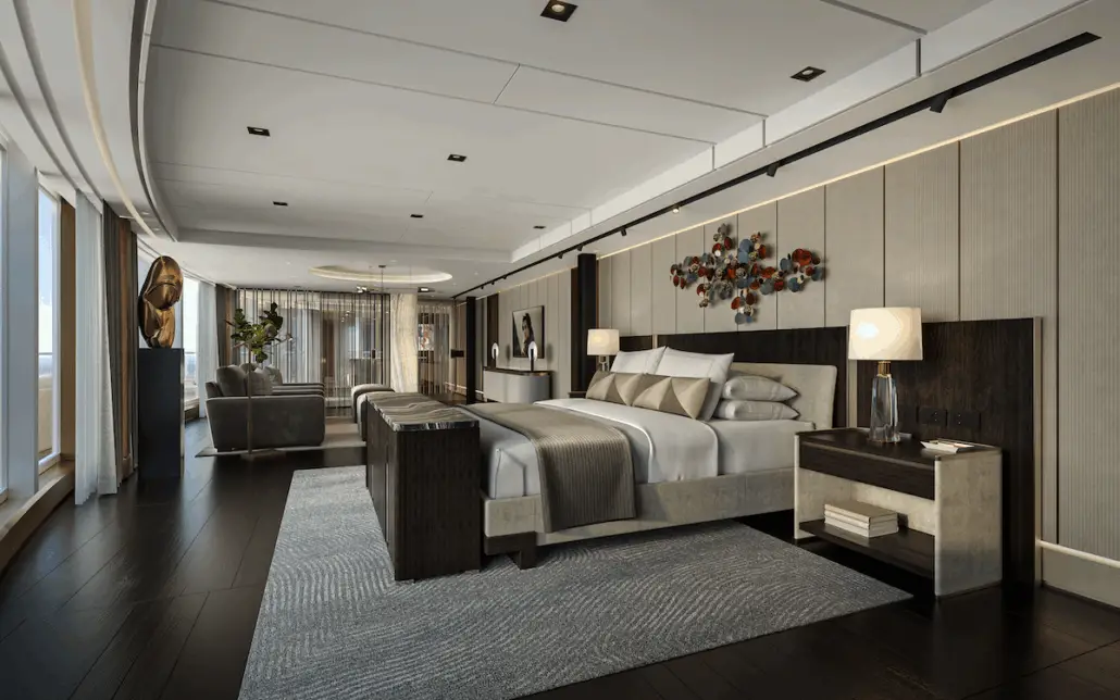 A spacious modern Skyview Suite bedroom aboard Regent’s new ship features a king bed, neutral tones, dark wood furniture, bedside lamps, striking wall art, large windows, and a stylish sitting area with contemporary decor.