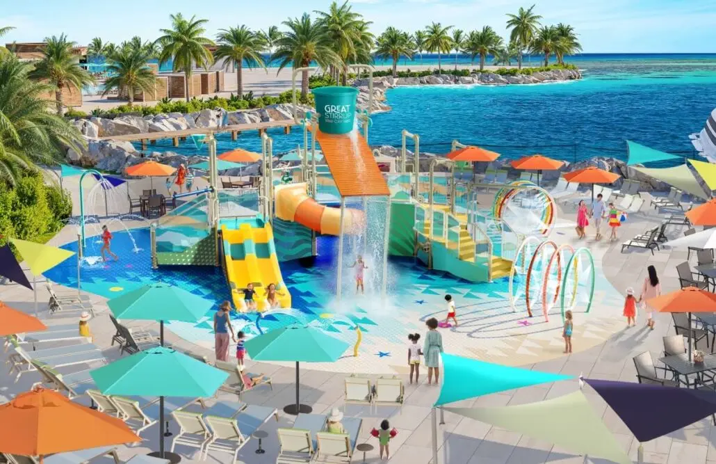 A colorful outdoor splash pad with water slides, fountains, and play structures on Great Stirrup Cay overlooks a blue ocean under a sunny sky. Children and adults enjoy the Norwegian Cruise Line water park, surrounded by lounge chairs and palm trees.