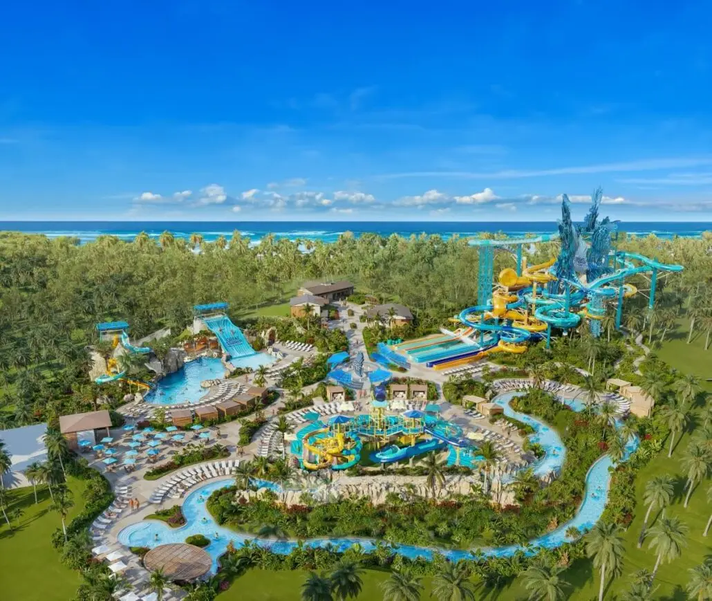 Aerial view of the expansive water park at Great Stirrup Cay, Norwegian Cruise Line’s private island, featuring water slides, pools, a lazy river, tropical landscaping, and lounge chairs with the ocean in the background under a blue sky.