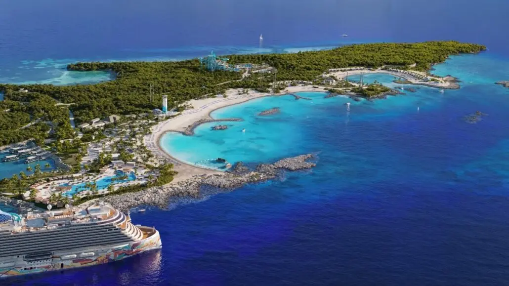 Aerial view of Great Stirrup Cay with white sand beaches, turquoise water, lush greenery, a Norwegian Cruise Line ship docked nearby, pools, a water park, and several buildings and recreational areas along the coastline.
