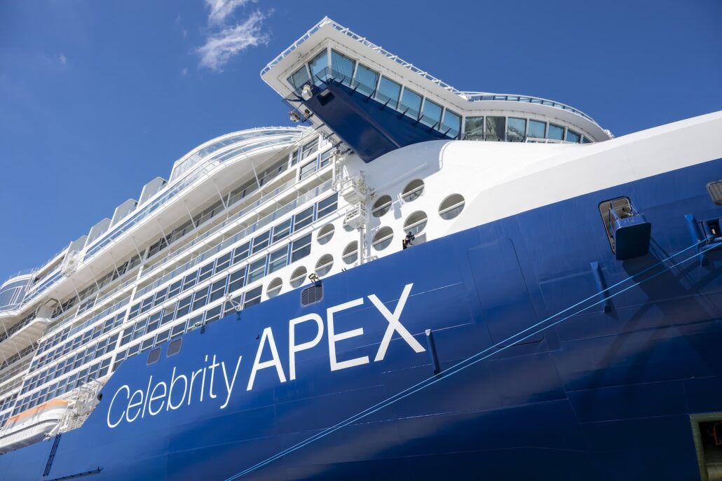 Close-up view of the Celebrity Apex cruise ship’s blue and white exterior, several rows of windows, and the bridge against a clear blue sky—perfect for Seven-Night Cruises from Florida's Space Coast.