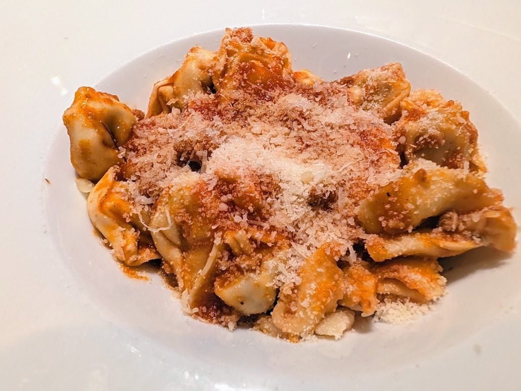 A bowl of tortellini pasta tossed in red sauce and topped with grated cheese, served aboard the Costa Toscana.